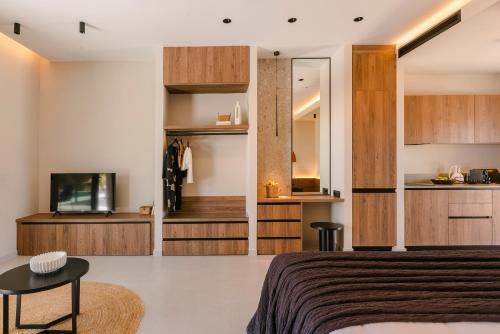 a bedroom with a bed and a tv and cabinets at Mast Luxury Residences in Gargaliánoi