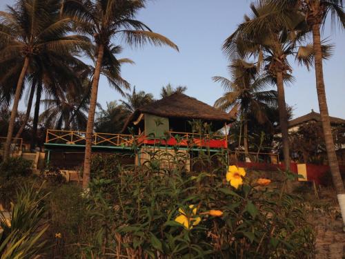 a resort with palm trees and a building at ECOLODGE SAFARI in Cap Skirring