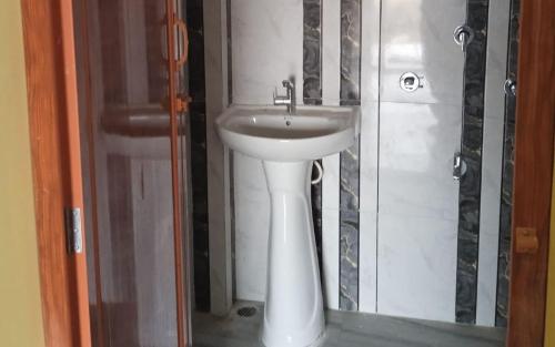 a bathroom with a white sink in a room at Bonmoyuri Sudarban by StayApart in Japur