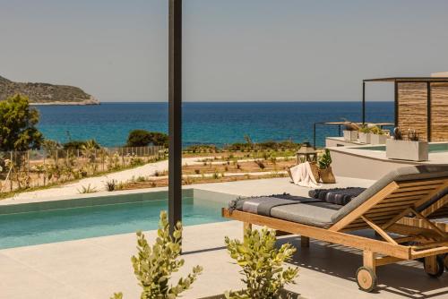 a patio with a lounge chair and the ocean at Mast Luxury Residences in Gargaliánoi