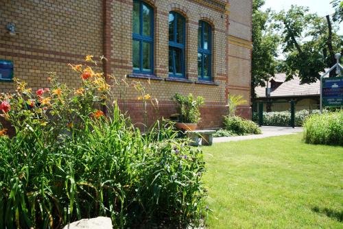 a brick building with a bench in a yard at Apartments am Schlosspark in Senftenberg