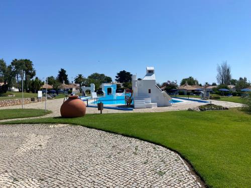 a resort with a slide and a swimming pool at Apartamento Pedras Del Rei - Casa Azul in Tavira