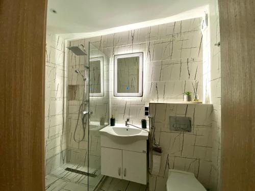 a bathroom with a shower and a sink and a toilet at AVRORA SUITE in Varna City