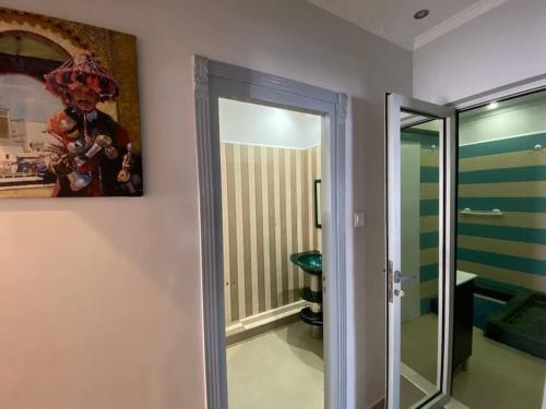 a bathroom with a mirror and a painting on the wall at Elegant appartement de 2 chambres sur bd Anfa in Casablanca
