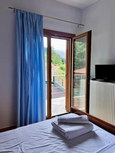 a bedroom with a bed and a sliding glass door at Villa Psarro Elato in Stournaraíïka