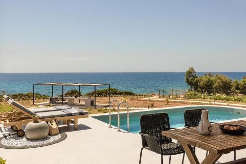 a swimming pool with a table and a picnic table at Mast Luxury Residences in Gargaliánoi