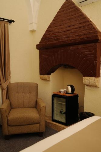 a living room with a chair and a television at Rüstempaşa Kervansaray Hotel in Edirne