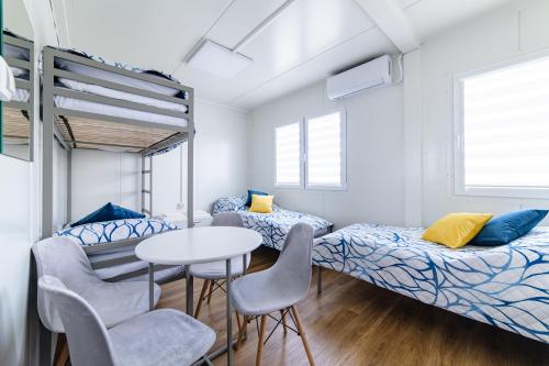 a room with two beds and a table and chairs at TASKAN Noclegi in Okmiany