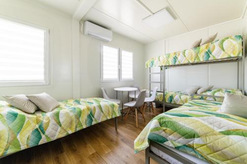 a bedroom with two beds and a table with chairs at TASKAN Noclegi in Okmiany