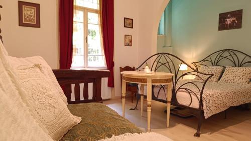 ein Zimmer mit zwei Betten und einem Tisch und einem Fenster in der Unterkunft Heritage Harmony with FREE PARKING in Budapest