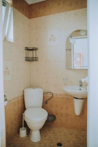 a bathroom with a toilet and a sink at вила Лора in Sinemorets