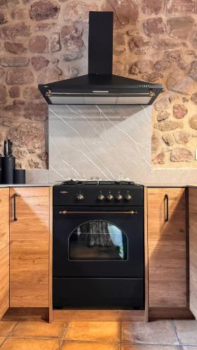 a stove in a kitchen with a counter top at Mas Morrenyà - Casa rural in Sant Jaume de Llierca