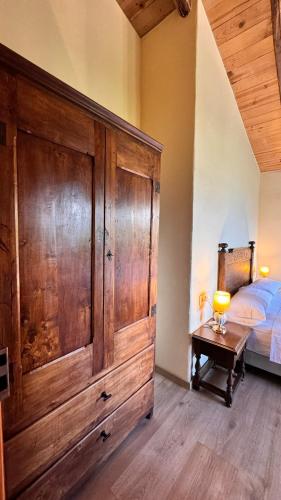 a bedroom with a large wooden cabinet next to a bed at Mas Morrenyà - Casa rural in Sant Jaume de Llierca