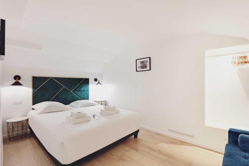 - une chambre blanche avec un lit blanc et un canapé bleu dans l'établissement Luxurious apartment - 3BR-6P - Nation, à Paris