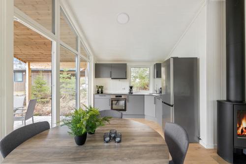 a kitchen and dining room with a table and a fireplace at Bjønntjønn 229 in Heimdal