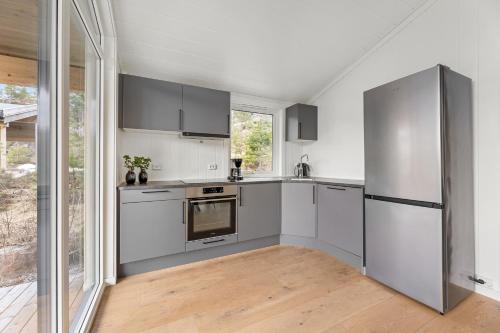 a kitchen with stainless steel appliances and a large window at Bjønntjønn 229 in Heimdal