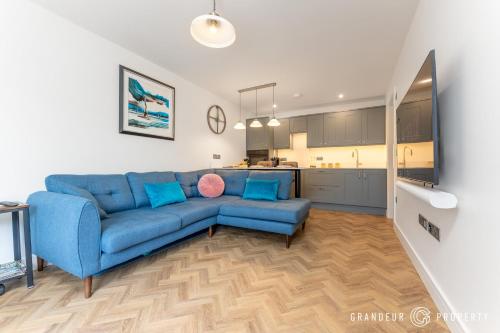 a living room with a blue couch and a kitchen at Harbour Haven by Grandeur Property in Poole