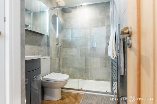 a bathroom with a toilet and a shower at Harbour Haven by Grandeur Property in Poole