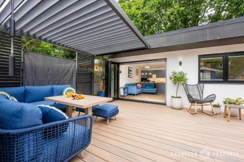a patio with a blue couch and a table at Harbour Haven by Grandeur Property in Poole