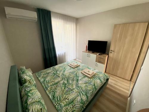 a small bedroom with a bed and a television at AVRORA SUITE in Varna City