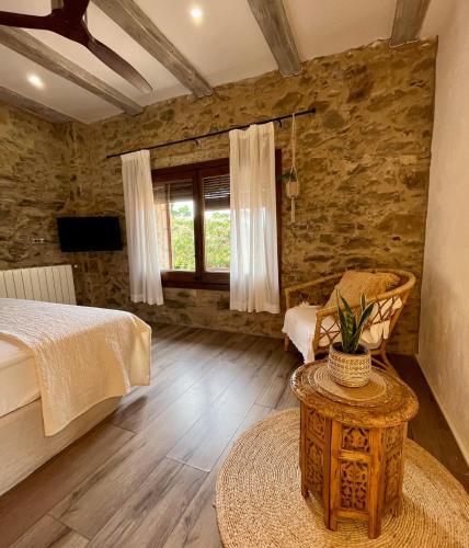 a bedroom with a bed and a table and a window at La Lolita ( Adults Only ) in Sant Martí Vell