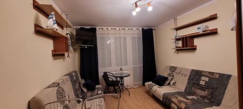 ein Wohnzimmer mit Sofa und Tisch in der Unterkunft Apartament NELA in Krynica Morska