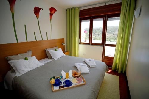 a hotel room with a bed with a tray with flowers on it at Sintra Sol - Apartamentos Turisticos in Sintra