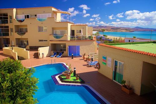 dom z basenem obok budynku w obiekcie Apartamentos Fuerteventura Sol w mieście Costa Calma