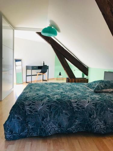 une chambre avec un lit avec une couette bleue dans l'établissement Duplex du Lion - 8 Voyageurs - Appartement 4 chambres supérieures, à Belfort