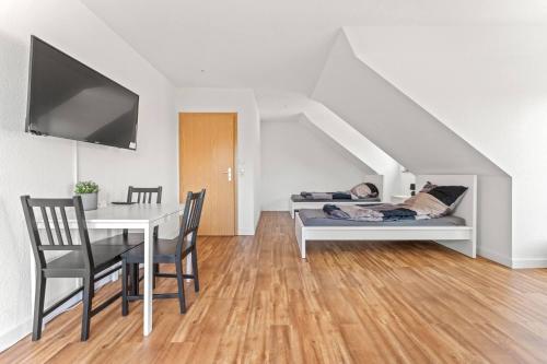 Una sala de estar con una mesa y una cama con una persona acostada en ella. en Nice Apartment in Bernau, en Bernau bei Berlin