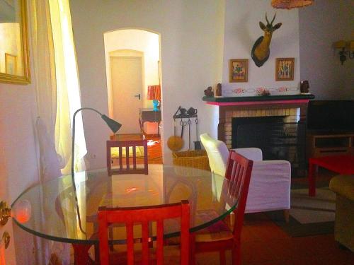 a dining room with a glass table and a fireplace at Herdade das Coutadas by Portus Alacer in Portalegre