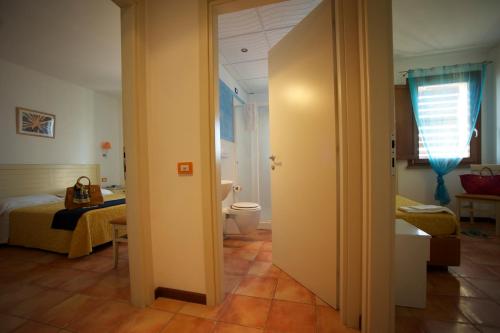 a bathroom with a bed and a toilet in a room at Hotel Villa Tramonto direttamente sul mare in San Vincenzo