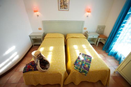 a bedroom with two beds in a room at Hotel Villa Tramonto direttamente sul mare in San Vincenzo