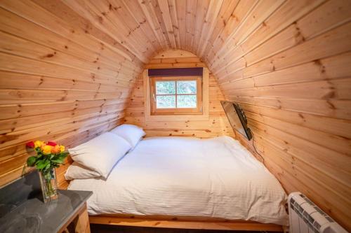 a bed in a log cabin with a window at Ocean View with hot tub in Barmouth