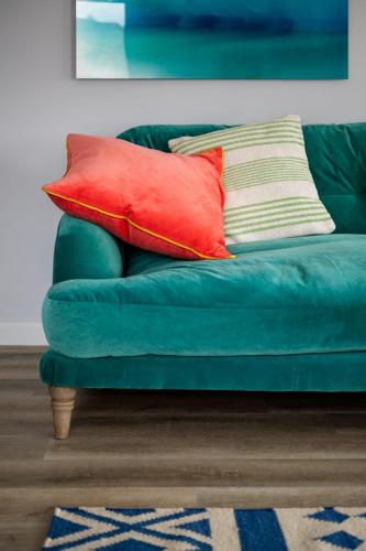 a green couch with two pillows on top of it at The Atelier Apartment in Kingsbridge