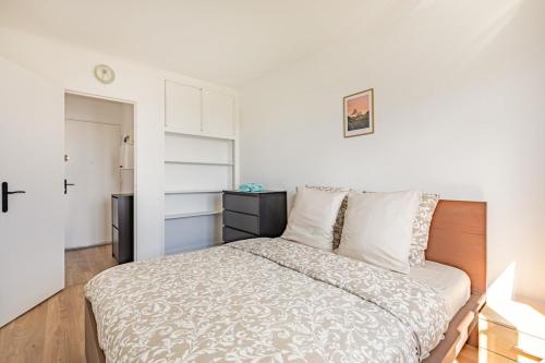 une chambre blanche avec un lit et un placard dans l'établissement Southern Paris - Near Metro Line 4, à Bagneux
