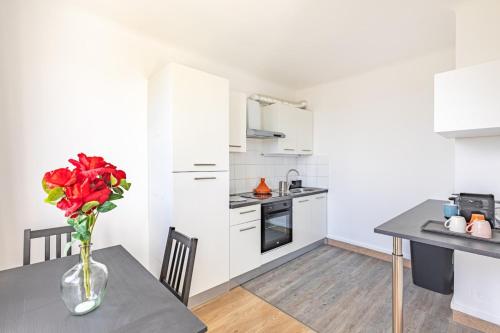 une cuisine avec une table avec un vase de fleurs dans l'établissement Southern Paris - Near Metro Line 4, à Bagneux