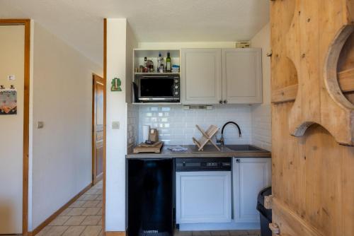 une cuisine avec des armoires blanches et un comptoir noir dans l'établissement Le Morylan - Immoclean, à Morillon