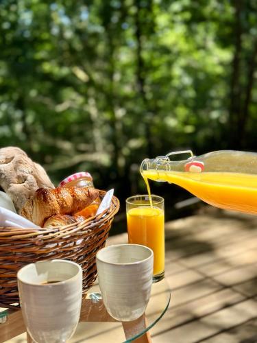 un pique-nique avec un panier de pain et du jus d'orange dans l'établissement Wild Lodge, à Lasséran