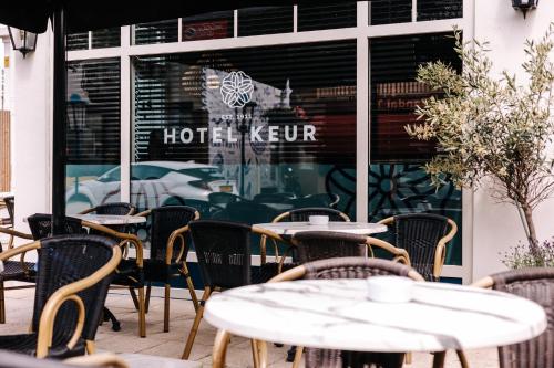 an outdoor cafe with tables and chairs in front of a building at Hotel Keur - Apartments in Zandvoort