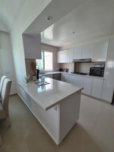 a kitchen with white cabinets and a white counter top at My Cosy Place Rabat - Cosy Home Wifak Temara in Temara