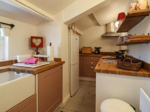 a kitchen with a refrigerator and a counter top at Emily Cottage in Keighley