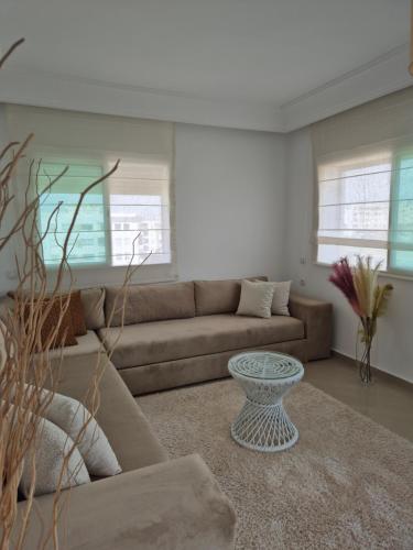a living room with a couch and a table at My Cosy Place Rabat - Cosy Home Wifak Temara in Temara