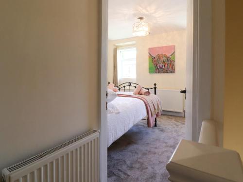 a bedroom with a bed with a pink blanket at Emily Cottage in Keighley