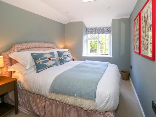 a bedroom with a bed with pillows and a window at Holly Cottage in Lyme Regis
