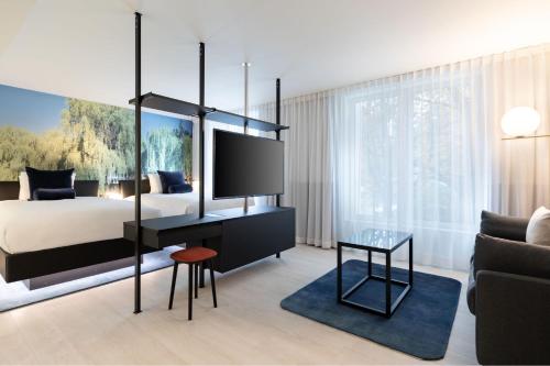 a bedroom with a bed and a tv and a couch at Residence Inn by Marriott Ghent in Ghent