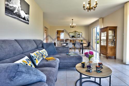 un salon avec un canapé bleu et une table dans l'établissement LocaLise - M19 - Ty Mervent - Maison avec jardin clos - A 2 pas de la plage - animaux admis - wifi inclus - draps inclus, au Guilvinec