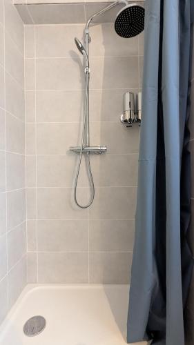 une douche avec un rideau de douche dans une salle de bain dans l'établissement Le Colibri - Parking Wifi, à Besançon
