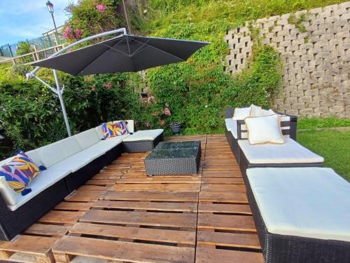 a patio with two couches and an umbrella at Casa Buena Vista in Candás