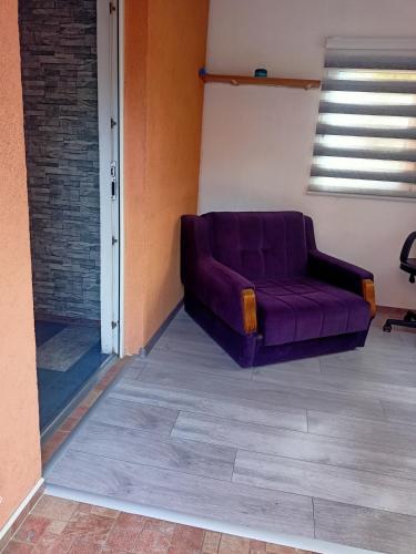 a purple couch sitting in the corner of a room at Apartment In The Nature in Ilidza
